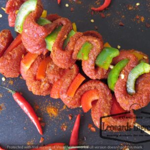 Close-up of a seasoned, spiced meat skewer with red and green peppers, representing the quality and precision of food processing equipment from Parkers Food Machinery Plus.