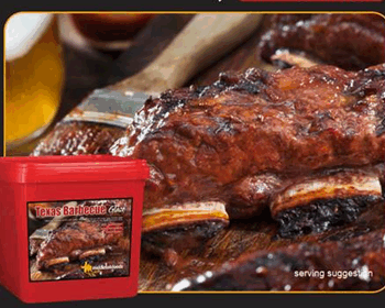 Texas Barbecue Sauce container with serving suggestion of glazed ribs, beer glass, and wooden cutting board in background