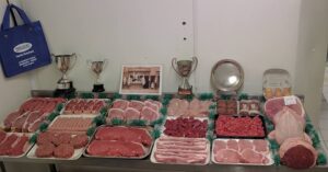 Award-winning meat selection from Hancocks Butchers in Monmouth displayed with trophies, showcasing quality cuts and butchery excellence at PFM Plus.