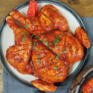 Spatchcock chicken with buffalo seasoning, oven-roasted for crispy skin and juicy flavor at PFM plus