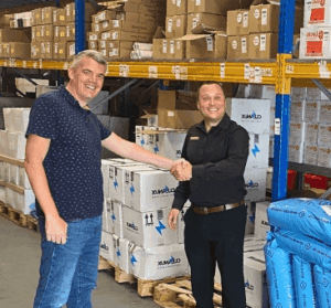 Parkers Food Machinery Plus team member shaking hands with a distributor partner in a warehouse, highlighting stronger service and product range for 2026.